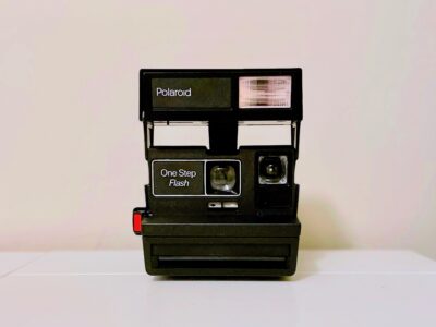 A Polaroid OneStep Flash 600 Film Camera on a white table